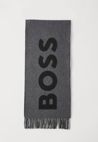 Grå tørklæde lavet af blødt stof med ordet "BOSS" i fed, sort skrift. Afsluttet med lange frynser i kanterne for ekstra tekstur.