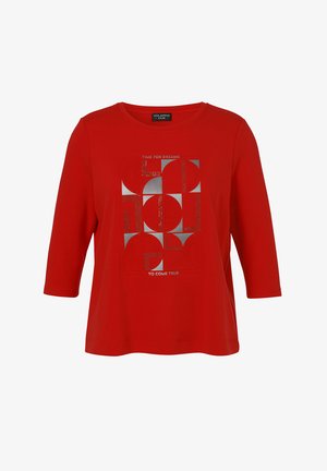 Rood shirt met driekwart mouwen, voorzien van abstracte zilveren geometrische vormen en de tekst "TIME FOR DREAMS TO COME TRUE" aan de voorkant.