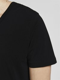 T-shirt noir à col en V avec des manches courtes, en coton lisse, et des coutures soignées le long du col et de l'ourlet.