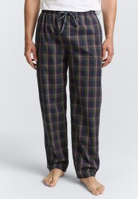 Pantalons de pyjama à carreaux marine et verts en tissu doux, avec une taille élastique dotée d'un cordon de serrage et un zip à bouton.