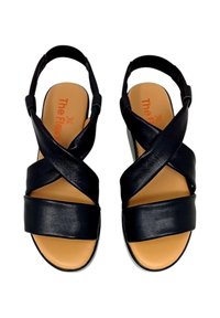 Sandali in pelle nera con cinghie incrociate, design con tacco aperto, plantare imbottito beige e suola piatta. Nome del marchio visibile all'interno.