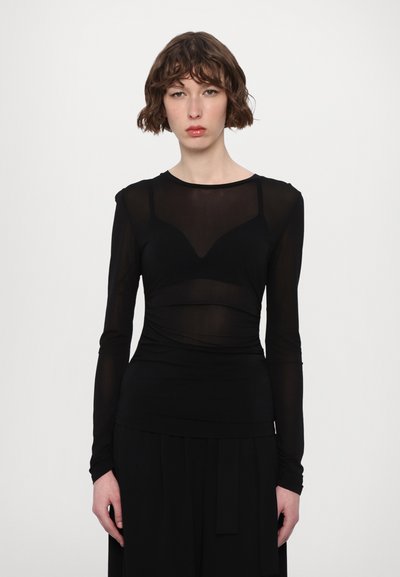 Camiseta negra de manga larga hecha de material transparente, con un diseño ajustado, fruncidos en la cintura y un cuello redondo con un sutil efecto en capas.
