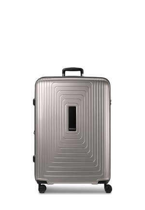 Maleta rígida plateada con diseño texturizado de rectángulos concéntricos, asa negra, cuatro ruedas y una etiqueta rectangular negra en el centro.