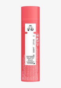 Conteneur de blush liquide en rose pastel, en forme cylindrique avec un capuchon transparent. L'étiquette présente un texte multilingue et des icônes d'avertissement.
