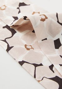 Tissu floral dans des tons de rose doux avec des accents noirs. Présente une surface texturée et un motif répétitif de grandes fleurs stylisées.