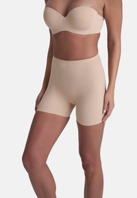 Beige shapewear shorts van glad, rekbaar materiaal. Middelhoge taille met een naadloos ontwerp en een openingdetail aan de voorkant.