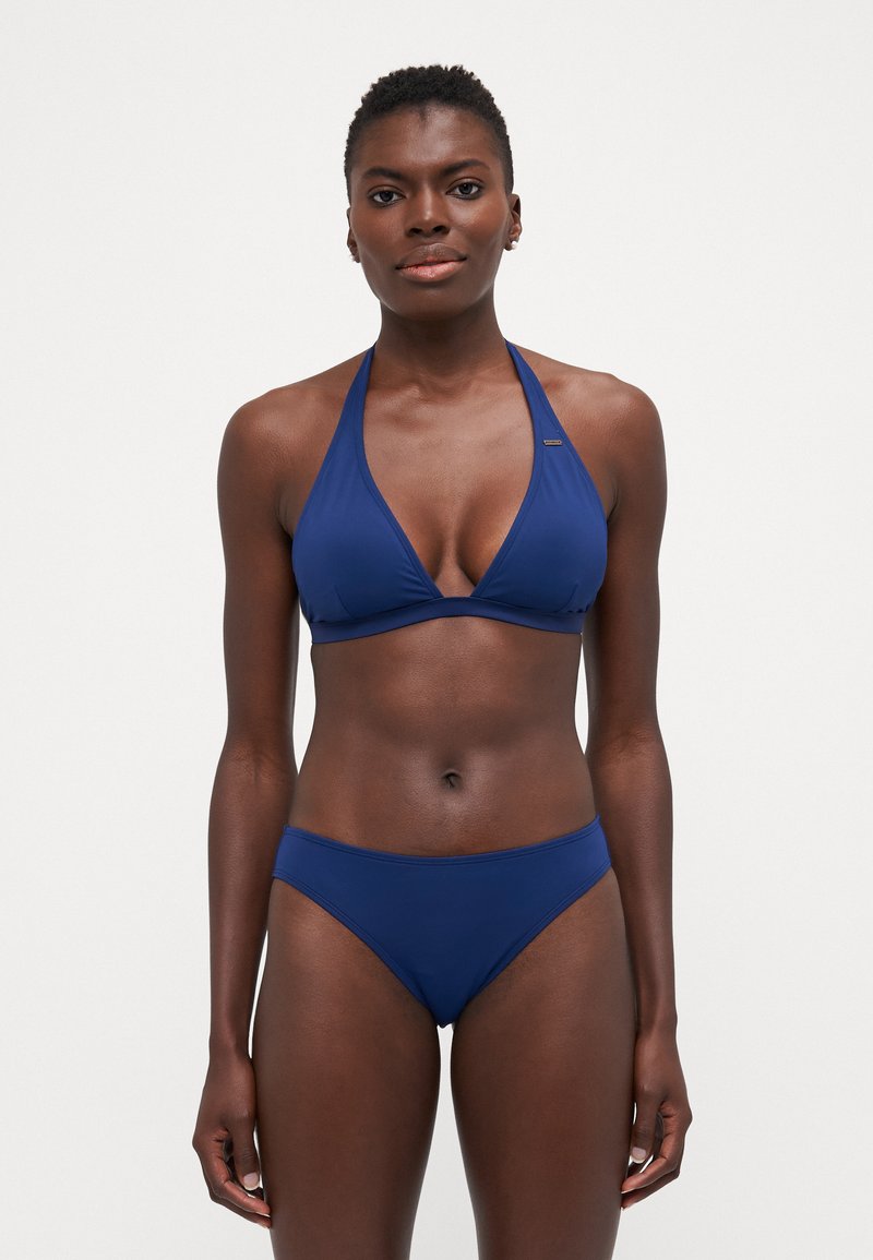 Niebieski zestaw bikini z halterowym stanikiem i pasującymi, nisko osadzonymi figami. Wykonany z gładkiego, elastycznego materiału z minimalnymi detalami szwów.