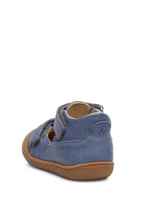 Modrá kožená bota s polstrovaným šedým páskem, kulatým tvarem a hnědou gumovou podrážkou. Disponuje výřezem pro prodyšnost.