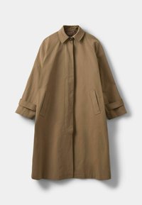 Barna gombos kabát, pólónyakú, raglán ujjakkal és két oldalzsebbel. Relaxált fazonnal és sima textúrával rendelkezik.