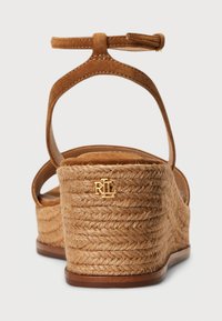 Hnědé espadrilkové sandály na klínu se semišovým páskem kolem kotníku, platformou obalenou jutou a zlatým logem na patě.