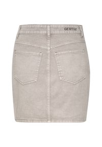 Jupe mini en denim gris avec cinq poches, un logo au dos et des détails de couture. Le tissu a une texture lisse avec un subtil motif délavé.