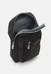 Zaino nero con un esterno in tessuto texture, interno grigio chiaro, doppia cerniera e una tasca frontale con logo.