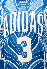 Μπλε και λευκή αθλητική φανέλα με το κείμενο «ADIDAS» και τον αριθμό «3» πάνω σε αφηρημένο φόντο με φύλλα.