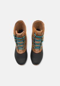 Ruskeat mokkanahkaiset nilkkurit mustilla kumipohjilla, joissa on turkoosit nauhat, tikatut yksityiskohdat ja teksturoitu varvasosa. Sopii rentoon käyttöön.