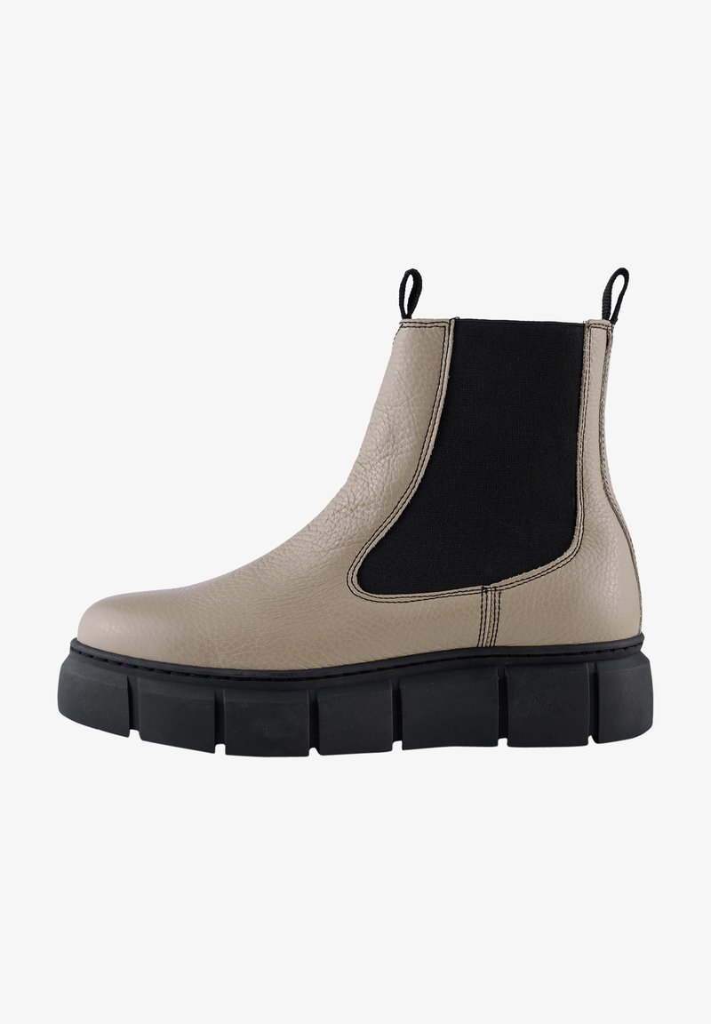 Botín Chelsea de cuero beige con paneles laterales elásticos negros, un upper texturizado y una suela de goma negra gruesa. Asa en el talón para facilitar el calzado.