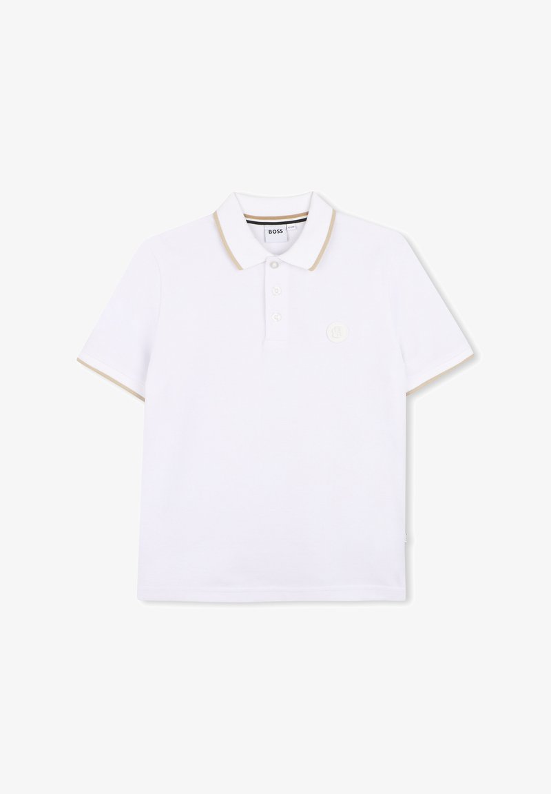 Polo blanc à manches courtes, avec des accents dorés sur le col et les manches, patte de boutonnage à trois boutons, et un petit logo sur la poitrine.