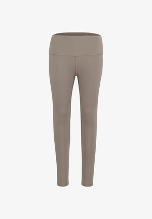 Beige elasztikus anyagból készült leggings, széles, lapos derékkal és sima felülettel, amelyek a kényelem és a szabad mozgás érdekében készültek.