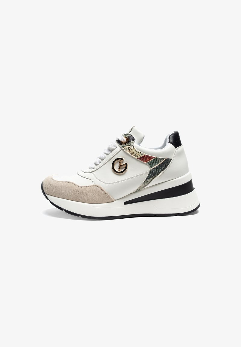 Sneaker bianca con dettagli in suede beige, pannello laterale testurizzato, tallone nero e logo metallico. Presenta lacci piatti e una suola spessa.