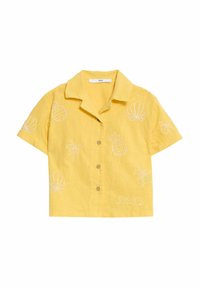 Korte mouwen gele blouse van linnen, met witte geborduurde patronen van ananassen, schelpen, palmbomen en golven. Vijf knopen aan de voorkant.