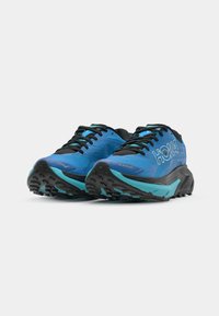 Zapatillas deportivas azules y negras con una parte superior de malla, suela gruesa y acolchada, y suela exterior de goma texturizada; presenta la marca HOKA en el lateral.