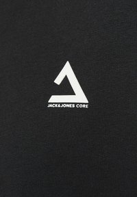 Tessuto nero con un logo triangolare bianco e la scritta "JACK & JONES CORE". La trama è liscia con un tessuto denso.