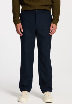 Navy blauwe op maat gemaakte pantalon van een wollen mix, met een rechte pasvorm, zijzakken en een subtiele merklogo op de tailleband.