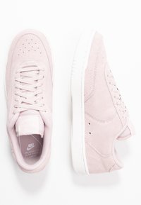 Sneakers in suede rosa con suole in gomma bianca, dotate di punta perforata, chiusura con lacci sul davanti e linguetta imbottita per un comfort ottimale.