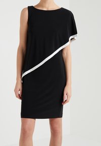 Czarna sukienka z asymetrycznym dekoltem, z ukośnym białym paskiem na piersiach. Wykonana z gładkiego, rozciągliwego materiału.