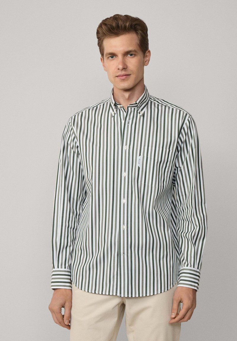 Camicia a maniche lunghe con bottoni, caratterizzata da righe verticali verdi e bianche. Presenta un colletto con bottoni e una tasca sul petto, realizzata in tessuto leggero.