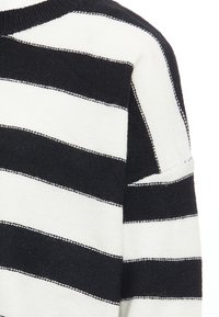 Black and white striped sweater featuring a textured knit, rounded neckline, and contrasting stitching along the stripes.