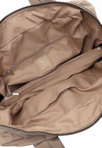 Beige Stofftasche, Innenraum mit zwei Reißverschlussfächern und einem kleinen eingenähten Logo-Patch mit dem Text "SubtleX".