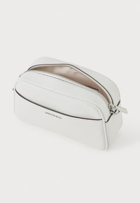 White leather cosmetic pouch with a rounded shape, silver hardware, double zipper closure, and a smooth pebbled texture.