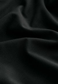 Black fabric with a smooth texture, featuring soft, flowing folds and subtle sheen. No distinct patterns or accents visible.