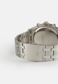 Edelstahlarmbanduhr mit silbernem Armband, glatter Oberfläche, rundem Gehäuse, Chronograph-Funktionen und einem Verschluss mit dem Markennamen.