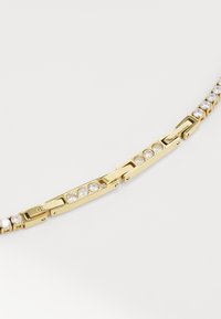 Bracelet plaqué or mettant en valeur des gemmes claires rondes espacées le long d'un design de maillons, avec le nom de la marque gravé sur les sections de fermeture.