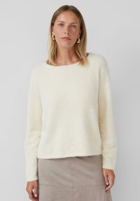 Crème-kleurige, fluffige trui met een ronde halslijn, lange mouwen en een relaxte pasvorm. Kenmerkt zich door een subtiele textuur en minimale detailing.