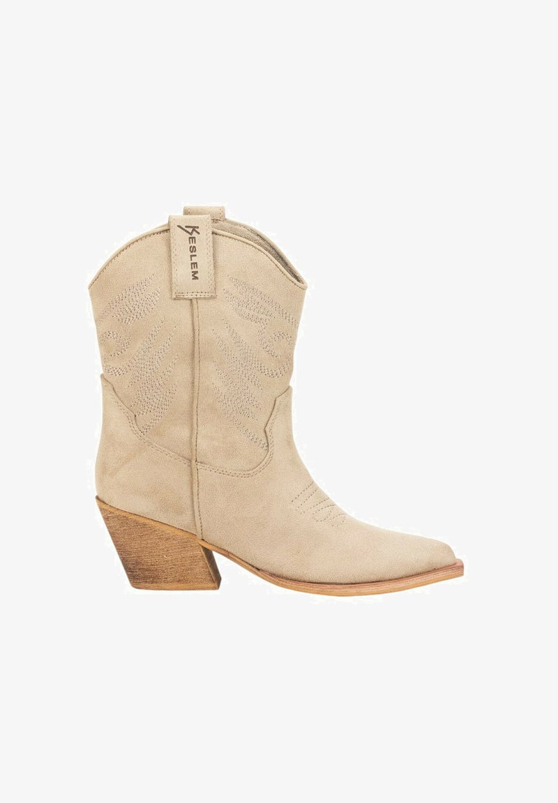 Botas de cowboy de ante beige con puntera afilada y detalle texturizado en el caña, con un tacón de madera apilada y una lengüeta en la parte trasera.