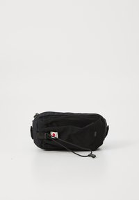 Pochette nera con zip realizzata in tessuto resistente, caratterizzata da una chiusura a coulisse, forma rettangolare piatta e un piccolo cartellino con logo.