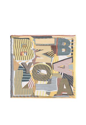 Bufanda con grandes letras con franjas superpuestas en tonos amarillo, naranja, azul y marrón sobre un fondo blanco con bordes con flecos.