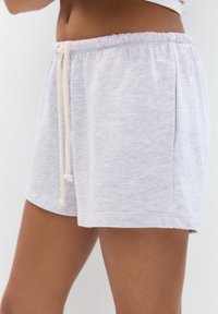 Grå bomullsblandning shorts med elastisk midja, med en dragsko med texturerade ändar och sidofickor. Mjuk, avslappnad design.
