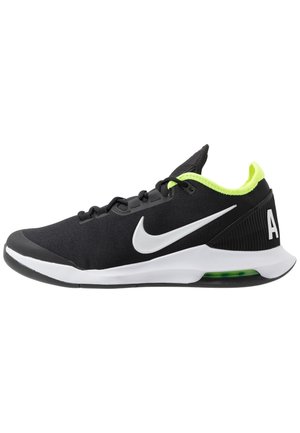 Czarno-biały but sportowy Nike z neonowo-żółtą wyściółką, białym logo Swoosh i widoczną amortyzacją powietrzną w podeszwie.