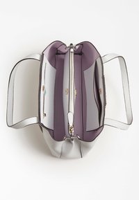 Sac à main structuré avec un extérieur doux et texturé gris clair. L'intérieur présente une doublure violette, deux compartiments et une poche zippée.