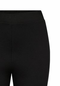 Fekete leggings sima, rugalmas anyagból, magas derékkal és láthatatlan varrásokkal vagy díszítésekkel, amelyek a kényelmet és a rugalmasságot szolgálják.