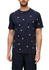 Granatowa koszulka z krótkim rękawem wykonana z bawełny, z rozsianymi wzorami zielonych liści na tkaninie. Okrągły dekolt i luźny krój.