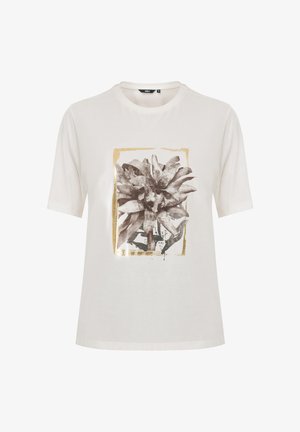 Camiseta de algodón blanca con corte suelto. Presenta un estampado floral en blanco y negro dentro de un rectángulo dorado. Mangas cortas, escote redondo.