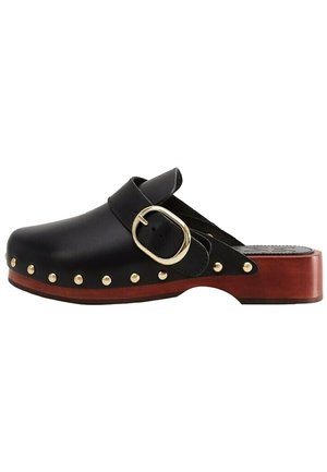 Sabot en cuir noir avec une large boucle dorée et des clous dorés le long de la semelle, avec un talon en bois marron et un design ouvert à l'arrière.
