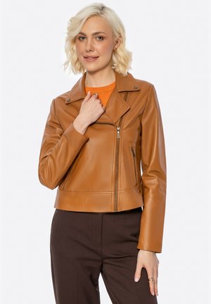 Giacca da moto in pelle finta marrone con colletto a scollatura, zip frontale e tasche laterali, abbinata a una maglietta di un vivace arancione.