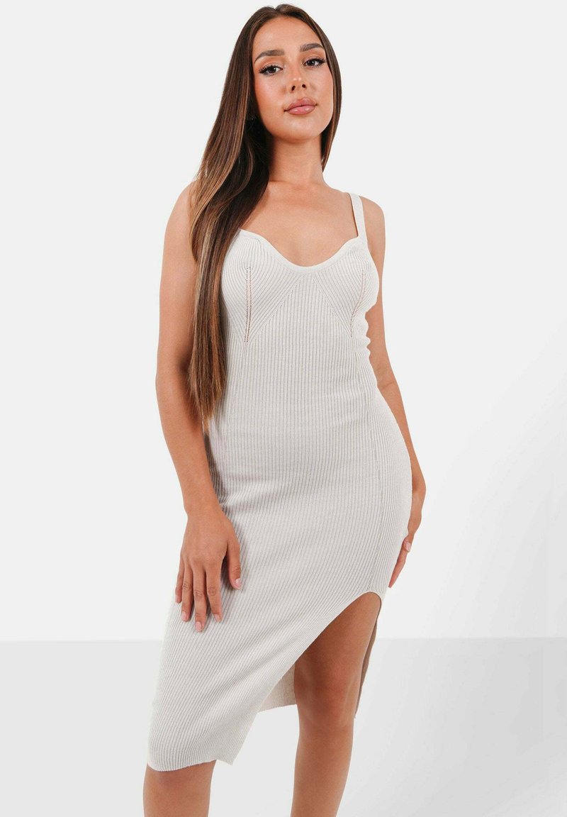 Rippstrickkleid in off-white mit taillierter Silhouette, Spaghetti-Trägern und einem asymmetrischen Saum mit einem bis Oberschenkel reichenden Schlitz.