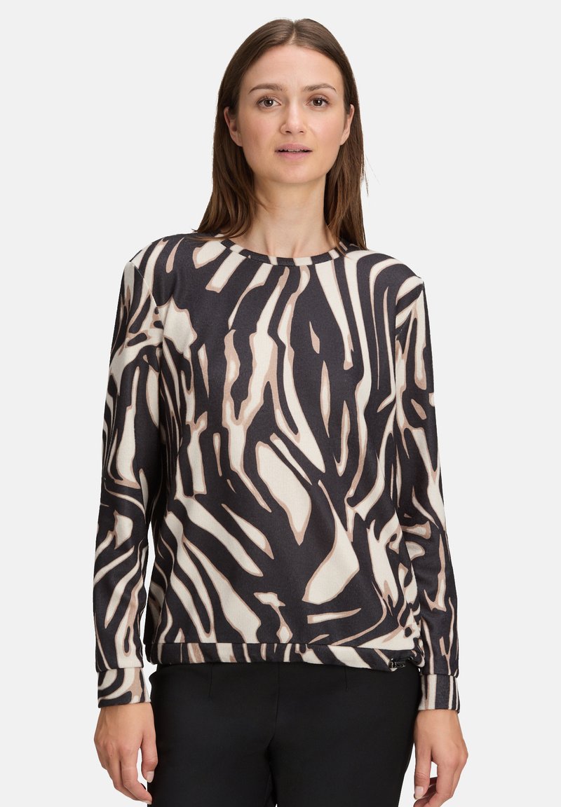 Lange mouwen top in een zwart en beige abstract patroon, gemaakt van een gestructureerde stof met een ronde hals en een rechte zoom.