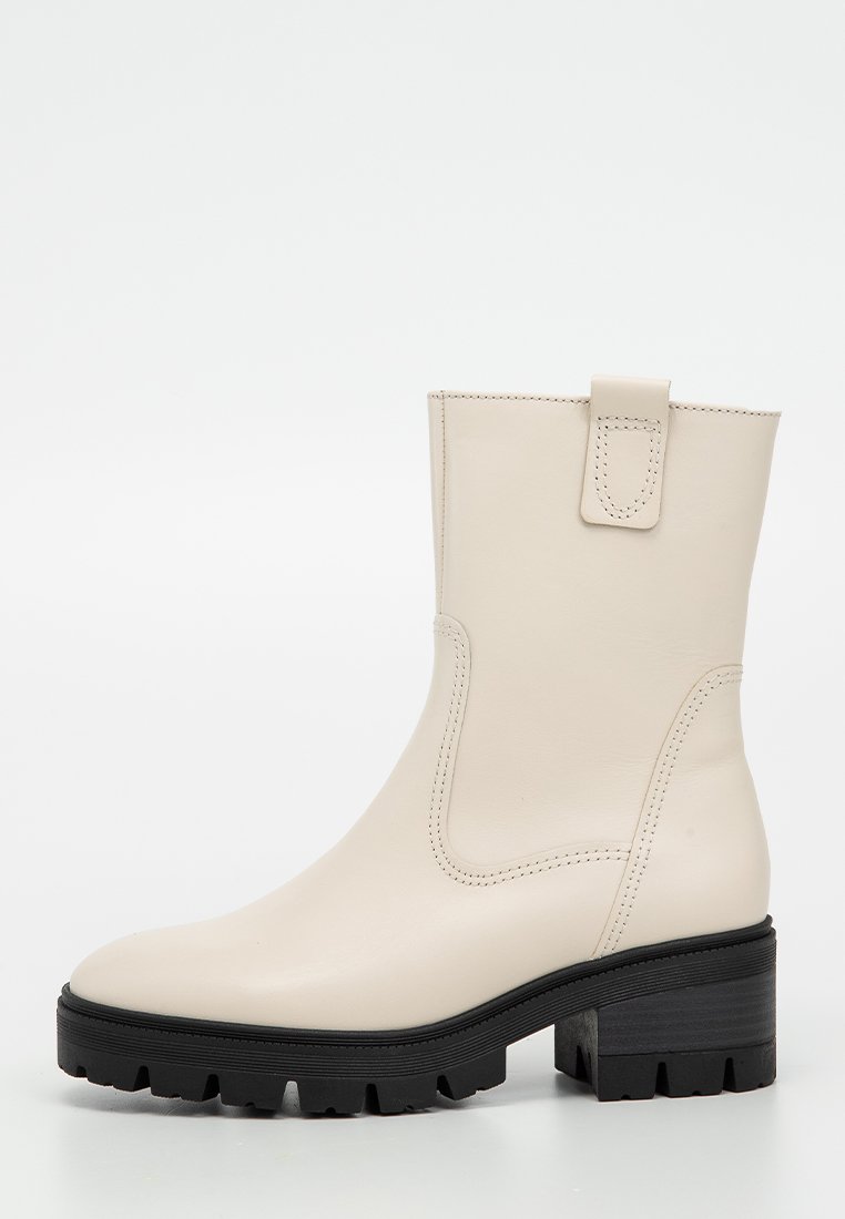 Beige Leder-Ankle-Boot mit glatter Oberfläche, schwarzer, klobiger Sohle und einer Ziehschlaufe auf der Rückseite. Verfügt über minimale Nähdetails.